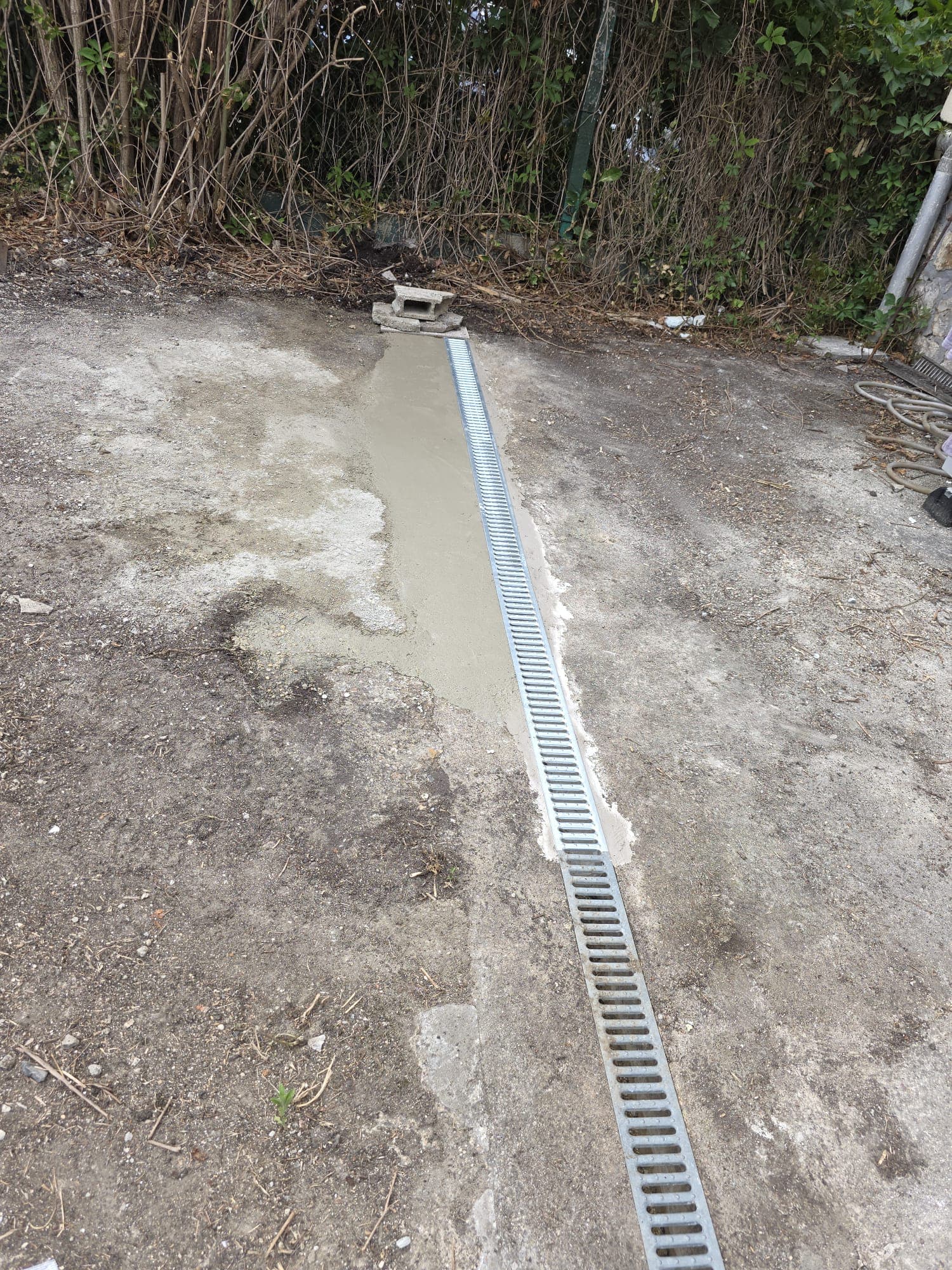 Zone rebouchée au mortier avec caniveau après remplacement de canalisation à Brunoy